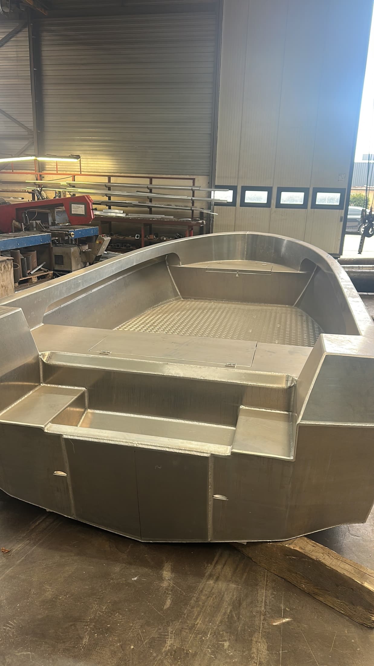 Unfinished aluminium workboat bow inside the workshop