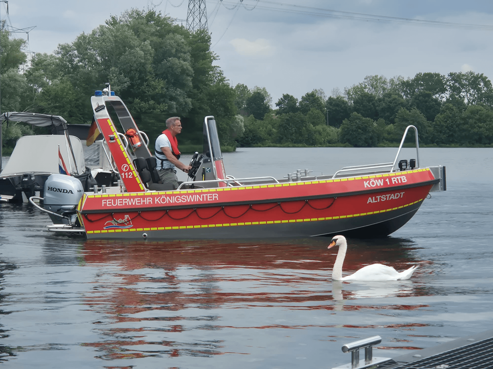 Side view of the red Tinn-Silver 530 rescue boat for Feuerwehr Königswinter on the water